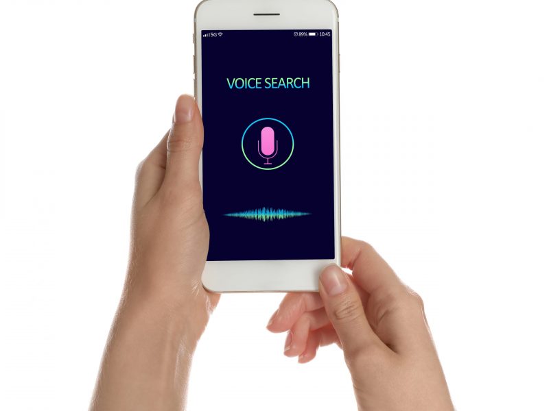 Woman using voice search on smartphone against white background, closeup